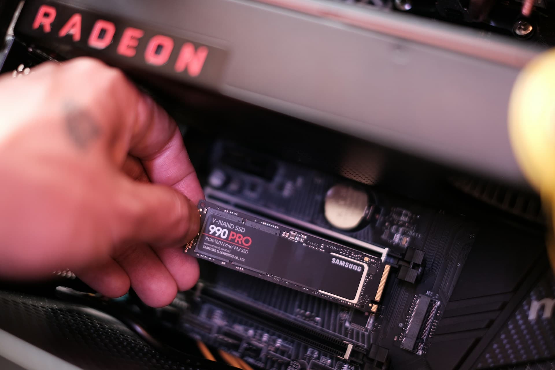 Samsung 990 Pro PCIe Gen 4 NVMe M.2 SSD being installed into a motherboard M.2 slot